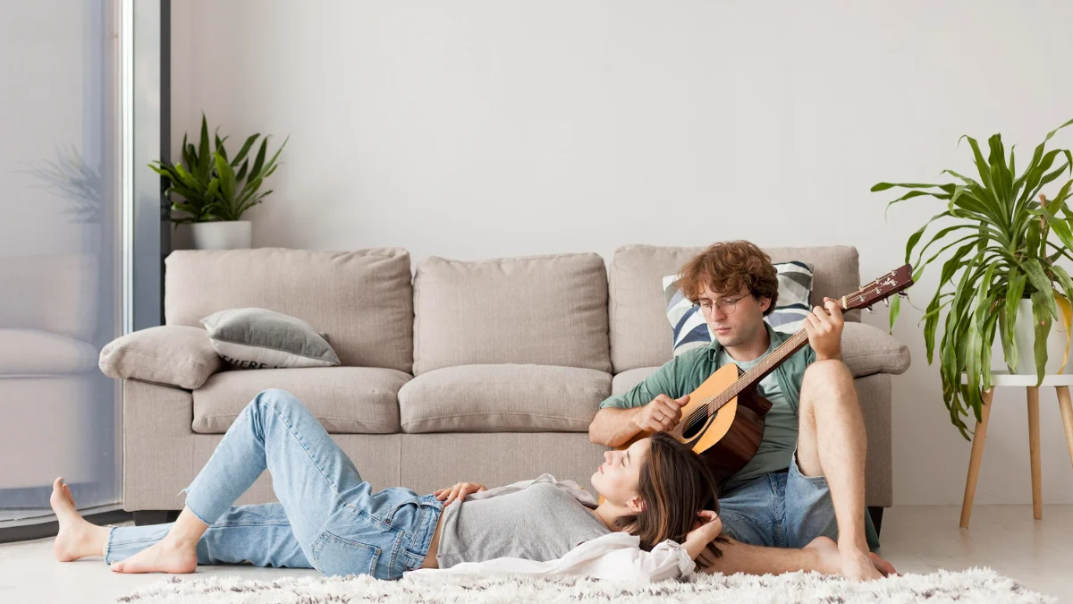 casal na sala, sentado no chão com homem tocando violão