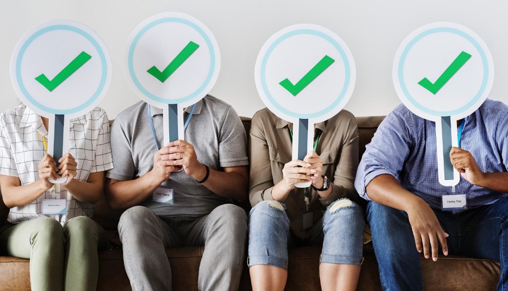 Grupo de pessoas segurando ícones de check