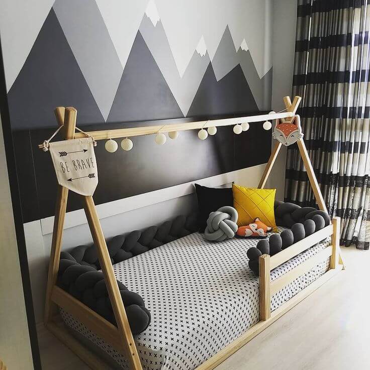Decoração Montessoriana - quarto infantil com cama baixa em formato de cabana e papel de parede com montanhas