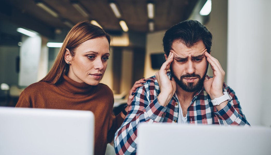 Erros do empreendedor: imagem de um homem e uma mulher preocupados olhando para a tela do computador