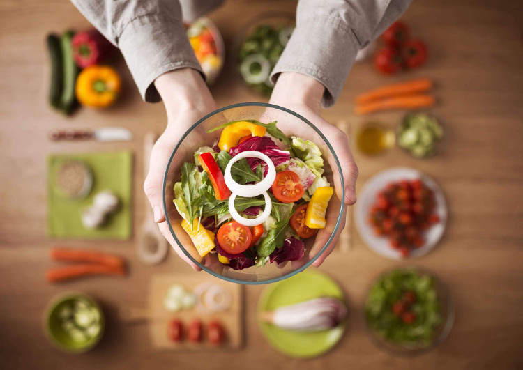 Alimentação saudável: imagem de uma pessoa segurando uma tigela com uma salada colorida.
